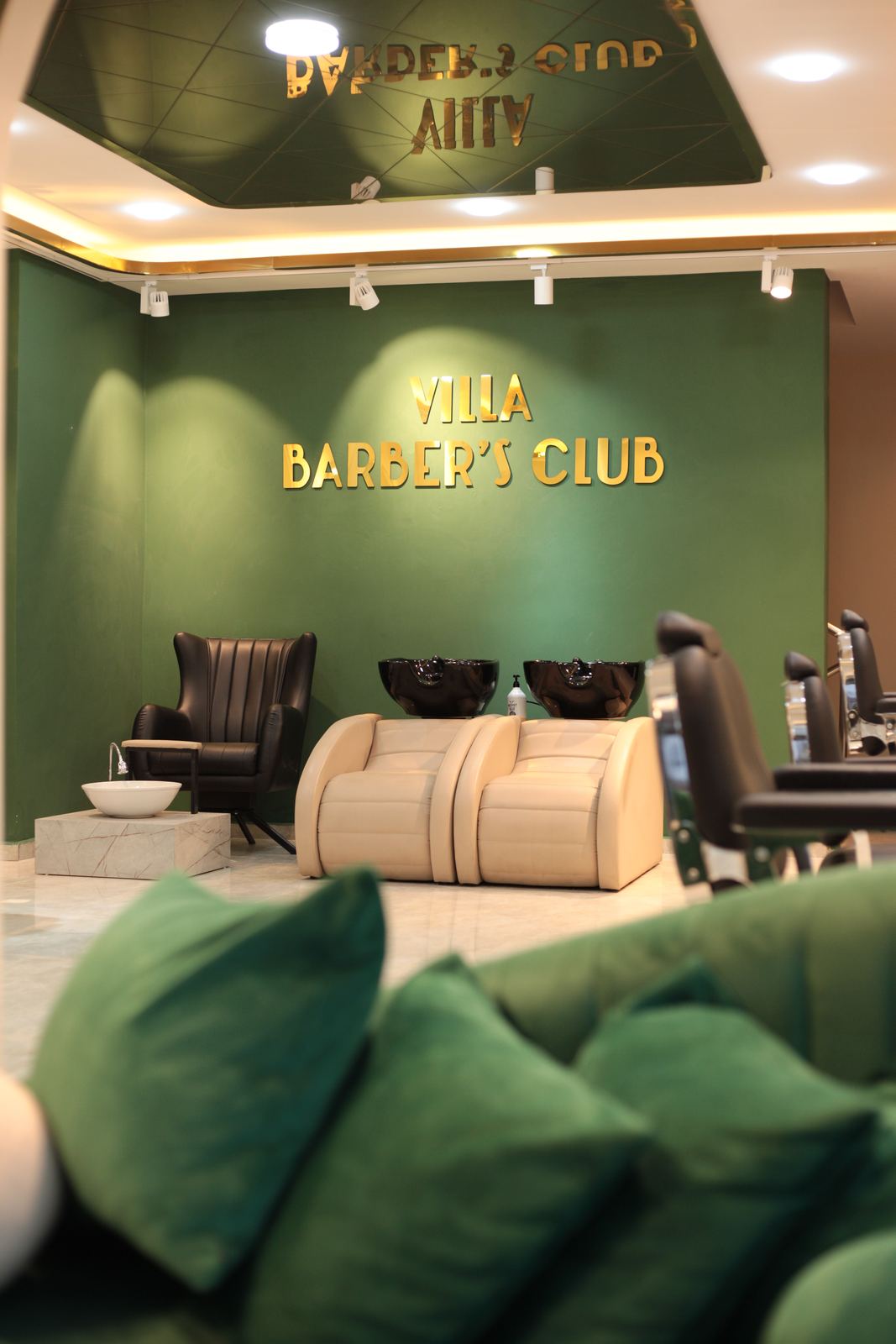 Villa Barber's Club salonunda bir berber, müşterisinin saçını keserken